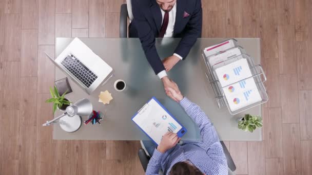 Two businessmen shaking hands sitting at the office, top view — Stock Video