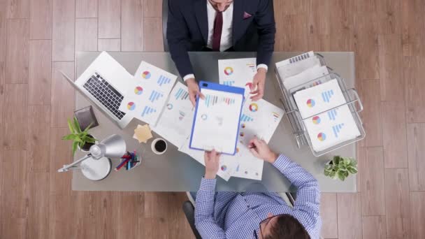 Top view of businessman in suit signing a contract after analysing agreement charts — Stock Video