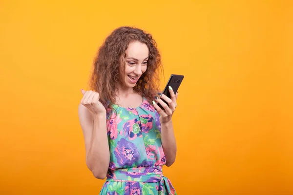 Telefonuna heyecanla bakan genç kadın — Stok fotoğraf