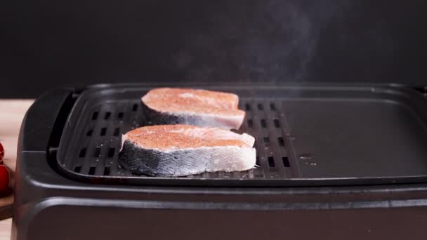 Primo piano della frittura di salmone fresco affettato sulla griglia elettrica — Video Stock