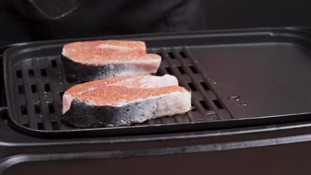 Повар переворачивает вкусного лосося, пока жарится на сковородке — стоковое видео