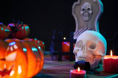 Cadılar Bayramı kutlaması için ahşap bir masaüzerinde mum ışığı altında korkunç kafatası