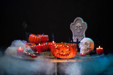 Cadılar Bayramı kutlaması için ahşap bir masada duman ve korkutucu kabak ile Oda.