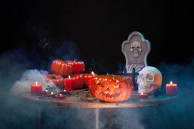 Duman ile ahşap bir masada farklı cadılar bayramı sembolleri