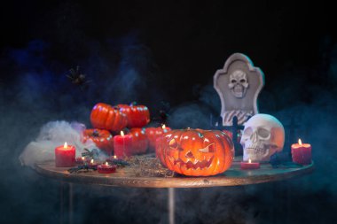 Turuncu kabaklar ahşap bir masada cadılar bayramı kutlaması için oyulmuş