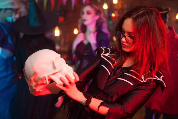 Хеллоуїн відьма з черепом перед своїми друзями-монстрами на вечірці на Хелловін — стокове фото