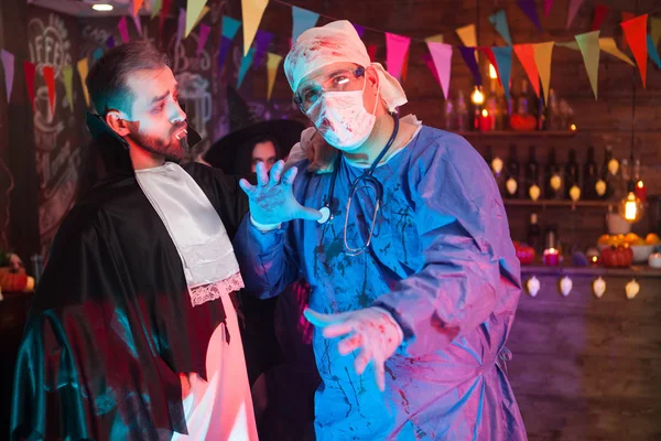 Dracula uomo guardando il suo amico medico mentre celebra Halloween — Foto Stock