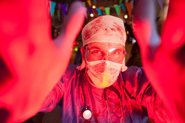 Cheerful young man dressed up like a creepy doctor for halloween