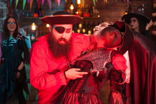 Człowiek w Dracula kostium gryzienie womans szyi ubrany jak wiedźma na Halloween — Zdjęcie stockowe