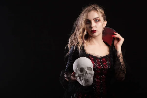 Incroyable fille morte habillée comme un vampire tenant un crâne pour le carnaval d'Halloween — Photo