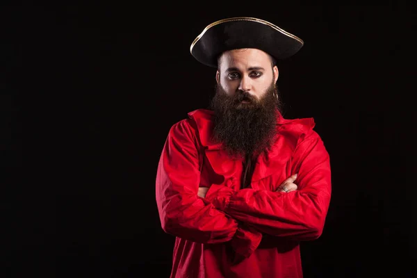 Kjekk skjeggete mann kledd som en pirat for halloweenkarneval holder armene krysset og ser inn i kameraet – stockfoto