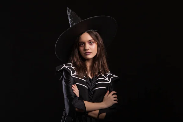 Lány csinál sötét varázslatok karját keresztbe, és súlyos kifejezése a Halloween karnevál — Stock Fotó