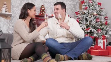 Güzel beyaz çift Noel arifesinde şampanya ile gözlük clinking