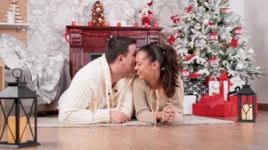 Güzel mutlu çift yerde yatan ve şampanya içme