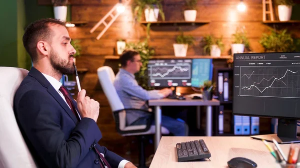 Biznesmen myśląc przed swoimi monitorami w biurze — Zdjęcie stockowe