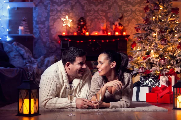 Foto de una hermosa pareja joven en casa en invierno celebrando la Navidad —  Fotos de Stock