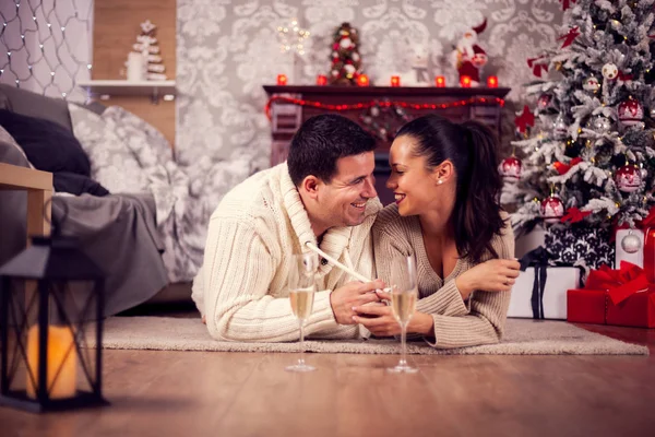 Beautifl joven marido y mujer tendidos en el suelo riendo en el día de Navidad —  Fotos de Stock