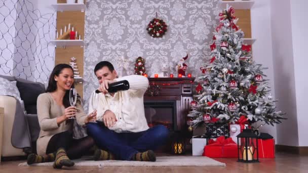 Feliz casal caucasiano bebendo champanhe no quarto decorado de Natal — Vídeo de Stock