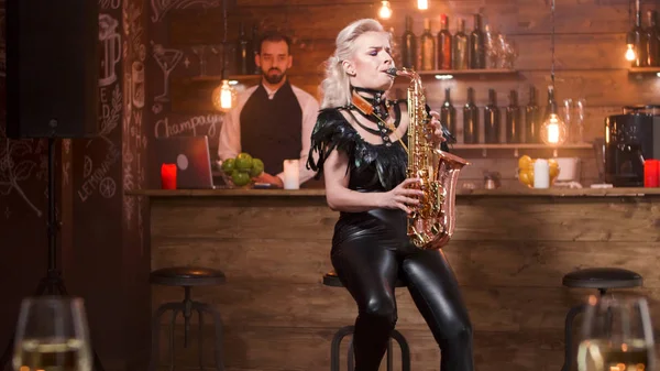 Side view of woman singing jazz on saxophone