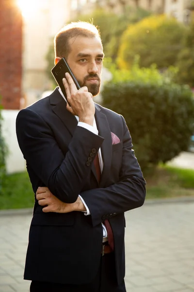 Homem de negócios concentrado falando ao telefone na rua — Fotografia de Stock