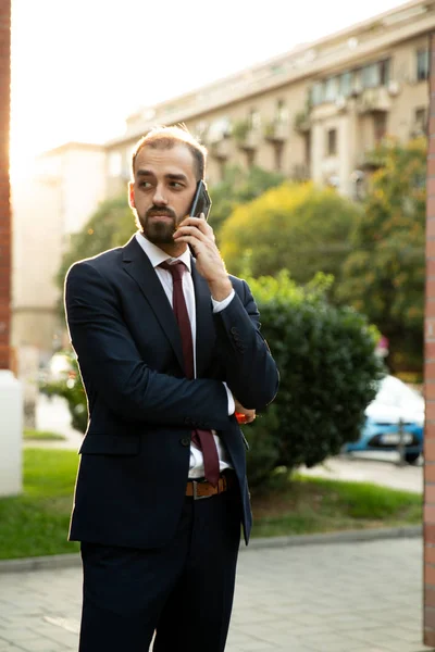 Empresário de sucesso falando ao telefone ao pôr do sol — Fotografia de Stock