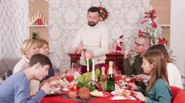 Noel şöleninde bir şişe şampanya açan adam