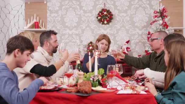 Grande famille dégustant un festin de Noël et des verres de champagne — Video