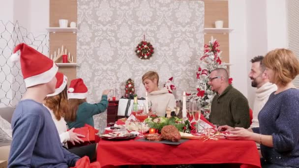 Grote familie geeft elkaar geschenkdozen voor kerstviering — Stockvideo