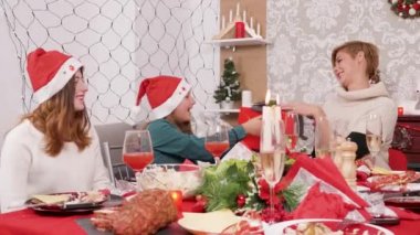 Noel şöleninde gülümseyen anne kızına hediye kutusu veriyor