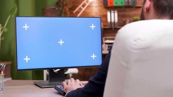 Man i sitt kontor arbetar och skriver på mock-up PC — Stockvideo