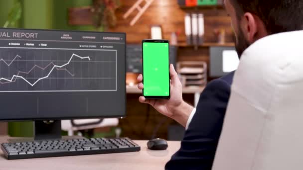 Empresario sosteniendo en la mano un teléfono con pantalla verde — Vídeo de stock