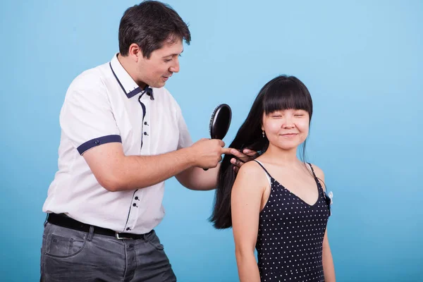 Caucásico novio cepillado su novia cabello en estudio — Foto de Stock