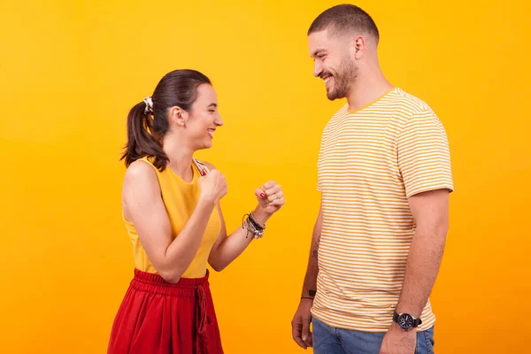 Sorrindo e bela namorada mantendo seus punhos na frente de seu namorado — Fotografia de Stock