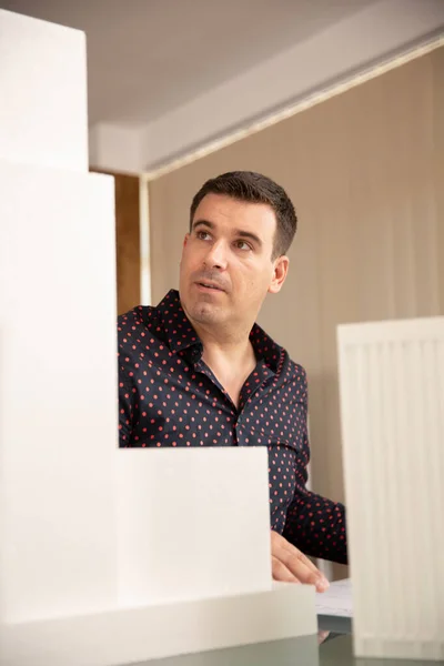 Male architect looking at 3D printed model of building — Stock Photo, Image