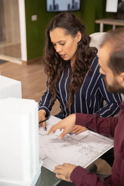 Arquitectos masculinos y femeninos mirando planos — Foto de Stock