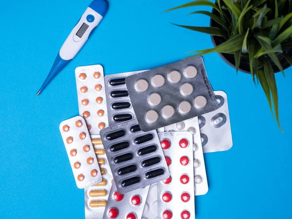 Termometresi olan üst manzara ve mavi arka planda çok renkli haplarla su toplaması.