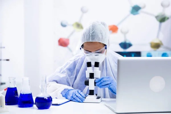 Ученые женщина в синей перчатке регулирует свой микроскоп — стоковое фото