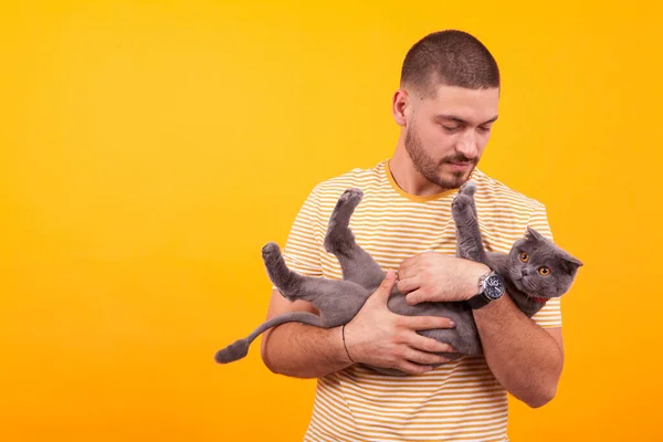 Bello giovane uomo amorevole e tenendo il suo gatto — Foto Stock