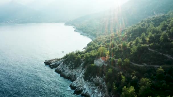 Drone vliegen over huis op rotsachtige kust lijn met prachtige turquoise zeewater — Stockvideo