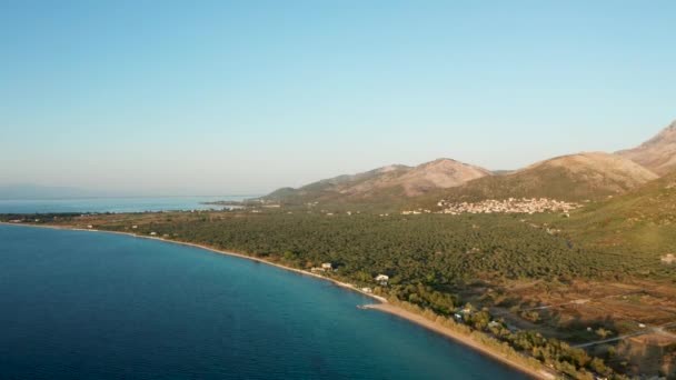 Dron, dağların yakınında mavi suyla denizin üzerinde uçuyor. — Stok video