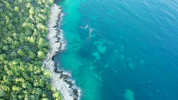 Dron letící podél skalnatého pobřeží s vlnami drtícími pobřeží — Stock video