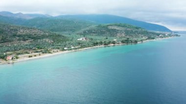 Turkuaz deniz suyuyla güzel kıyı şeridi üzerinde uçan insansız hava aracı.