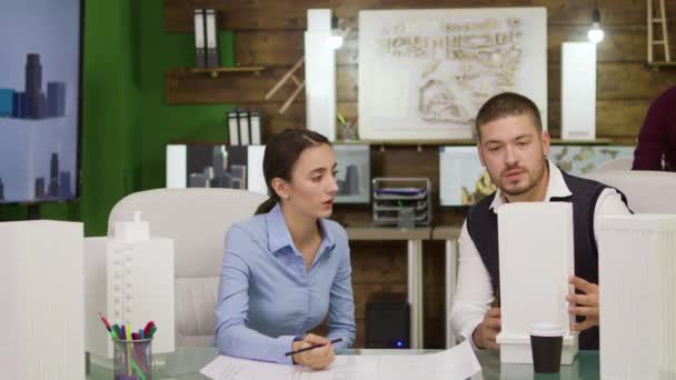 Dos jóvenes arquitectos trabajando en un plan urbano para edificios de oficinas — Vídeos de Stock