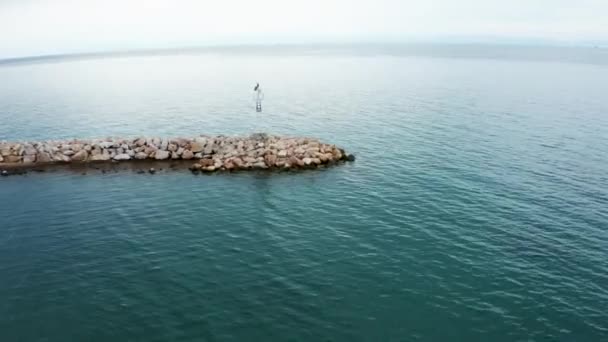 Съемка с воздушного беспилотника прибрежного маяка возле города — стоковое видео