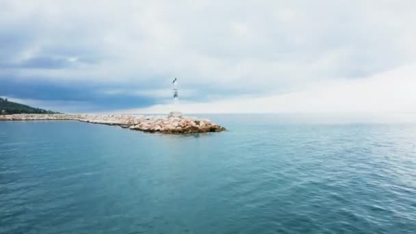 港の入り口にある小さな灯台の上を飛ぶドローン — ストック動画