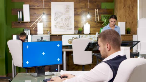 Joven arquitecto trabajando en una computadora con pantalla azul — Vídeos de Stock