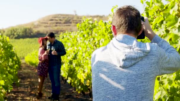 Фотограф фотографує милу пару в винограднику — стокове відео