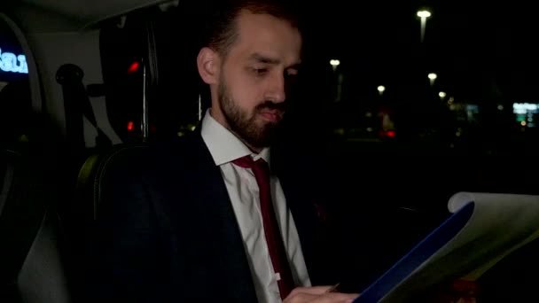 Moe zakenman na lange werkuren op de achterbank van zijn limousine — Stockvideo