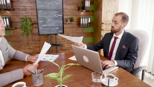 Empresario de traje trabajando en el portátil en la sala de conferencias — Vídeo de stock