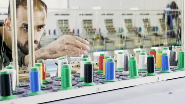 Человек, работающий на швейной фабрике, проверяет оборудование — стоковое видео